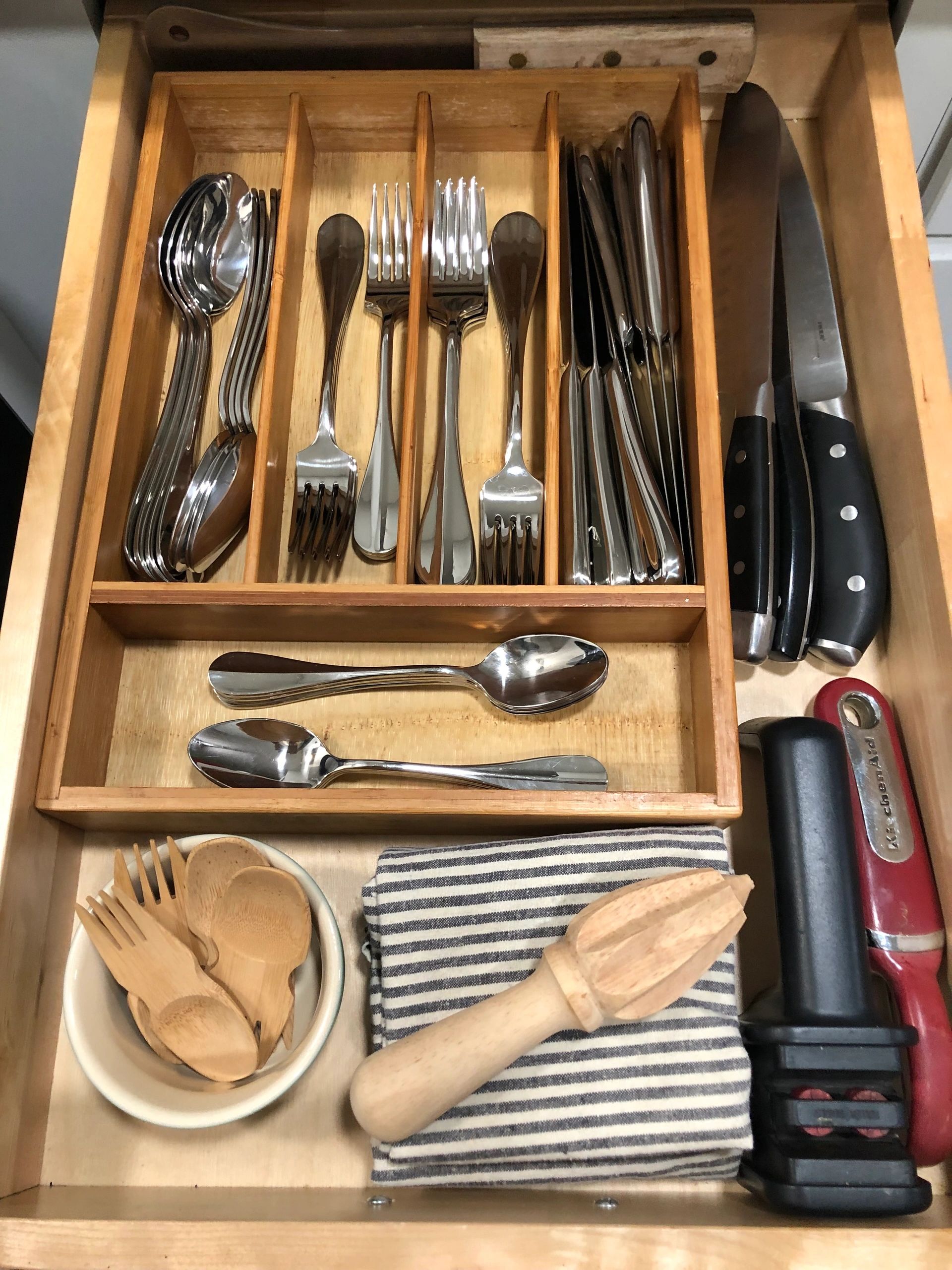 Open kitchen drawer with neatly sorted utensils